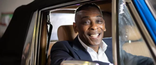 Man smiling in classic car